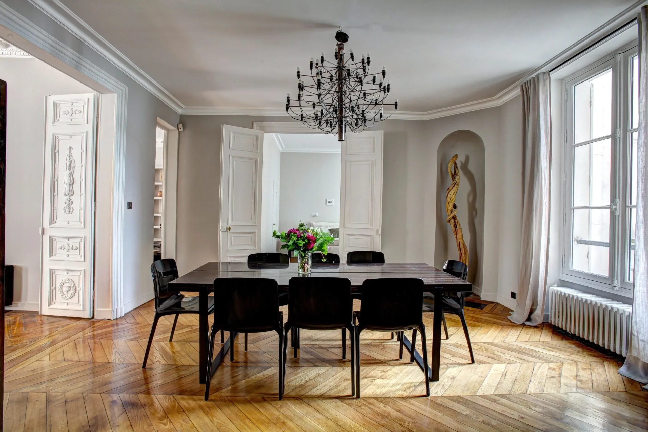 A dining table in a luxurious interiors of a house with decorative placed on the corner of a dining room